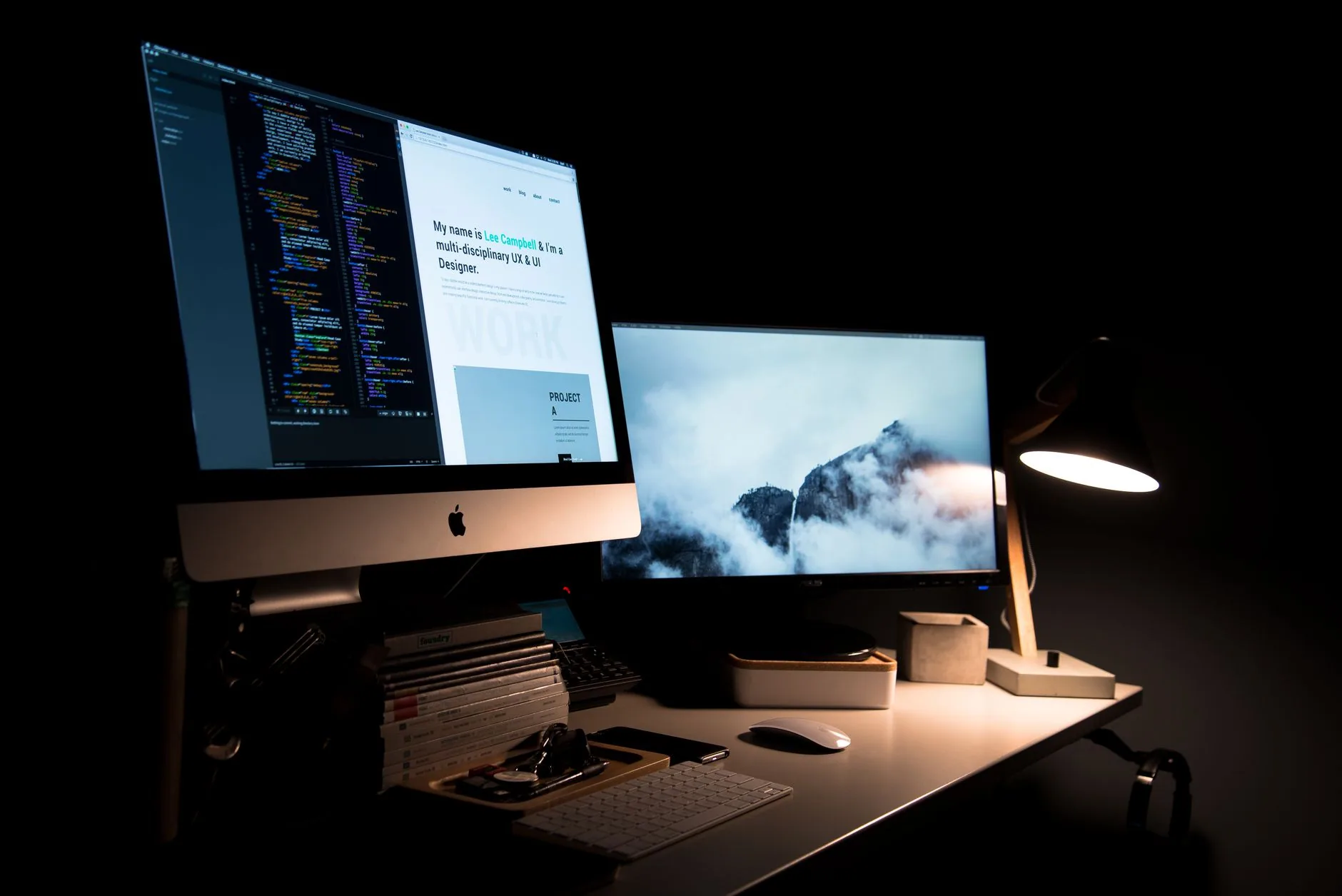 Un poste de travail avec deux écrans, une lampe et des fournitures