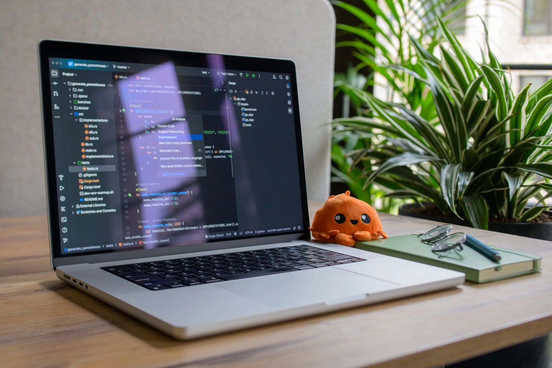 Un ordinateur portable affichant du code, posé à côté d’une plante verte