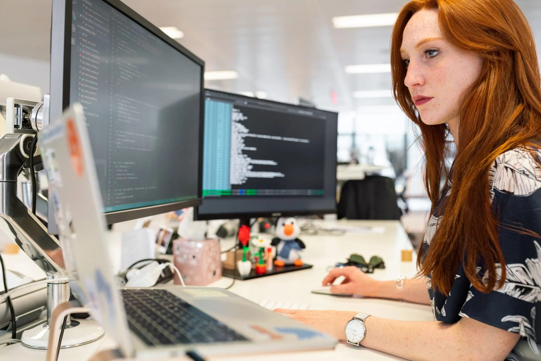 Une ingénieure logiciel codant sur deux écrans