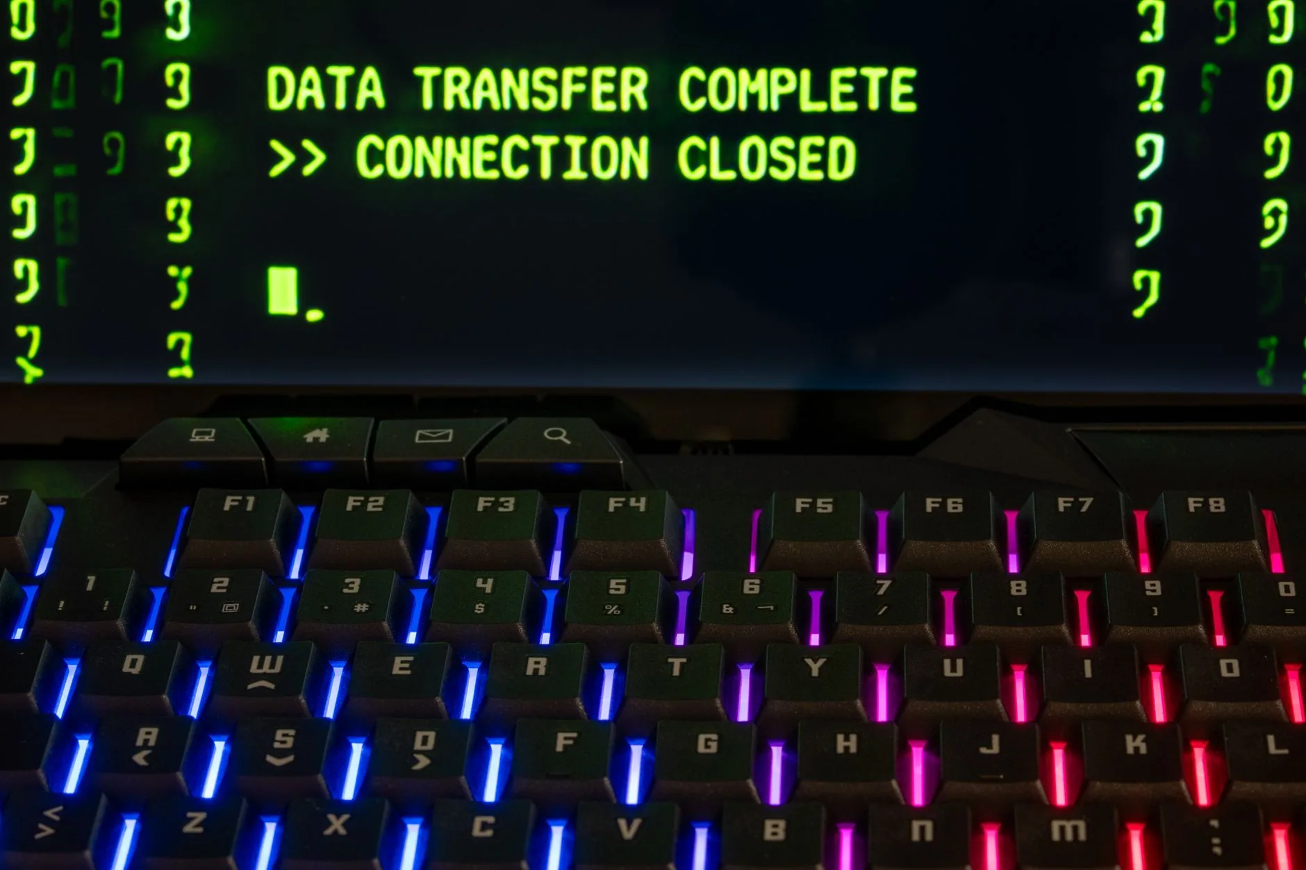 Un clavier rétroéclairé devant un écran affichant « Data Transfer Complete »